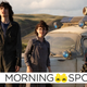 Finn Wolfhard's Trevor, McKenna Grace's Phoebe, and Logan Kim's Podcast stand in the sunlight in front of the Ecto-1.